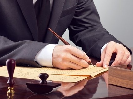 abogado firmando un papel con pluma